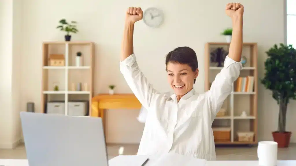 Joven emprendedora celebra frente al ordenador la concesión de ayudas de hasta 18.000 euros para autónomos en Castilla y León.