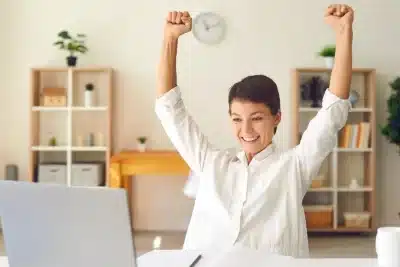 Joven emprendedora celebra frente al ordenador la concesión de ayudas de hasta 18.000 euros para autónomos en Castilla y León.