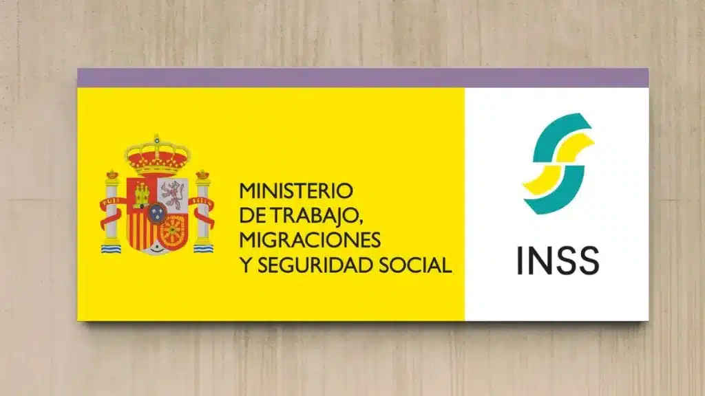 Cartel del Ministerio de Trabajo, Migraciones y Seguridad Social y del Instituto Nacional de la Seguridad Social (INSS) en la fachada de un edificio.