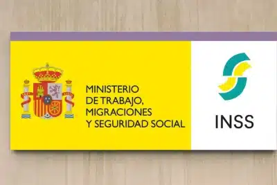 Cartel del Ministerio de Trabajo, Migraciones y Seguridad Social y del Instituto Nacional de la Seguridad Social (INSS) en la fachada de un edificio.