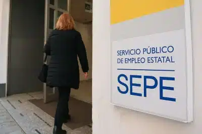 Mujer entrando a una oficina del SEPE (Servicio Público de Empleo Estatal) para realizar gestiones relacionadas con prestaciones.