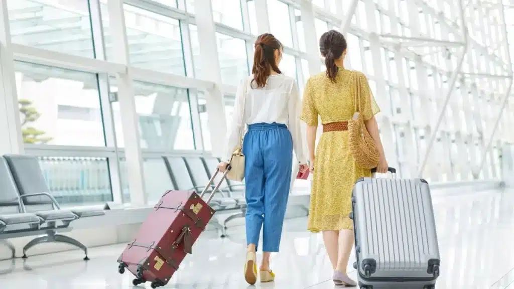 Mujeres caminando con sus maletas por un aeropuerto antes de viajar al extranjero.