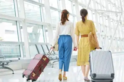 Mujeres caminando con sus maletas por un aeropuerto antes de viajar al extranjero.