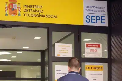 Entrada de una oficina del SEPE con un usuario esperando para acceder.