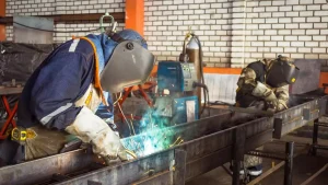 Trabajadores realizando labores de soldadura en un taller industrial.
